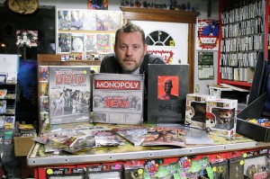 (WINDSOR, ON.) Shawn Cousineau, owner of Rogues Gallery Comics, poses with an array of The Walking Dead books and merchandise. Local artist Ron Suchiu will add an original painting to the growing pile memorabilia at an unveiling at Suchiu Gallery on October 26. (PHOTO BY// Y. MURAD ERZINCLIOGLU)
