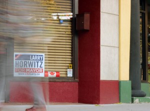 WINDSOR, ONT.: THURSDAY, SEPTEMBER 18, 2014. – A local resident walks by a political sign for mayoral candidate Larry Horwitz in the window of Humidor 1 Tobacconist on Ouellette Avenue in Windsor on Thursday, September 18, 2014. (The Converged Citizen Photo by / Justin Prince)