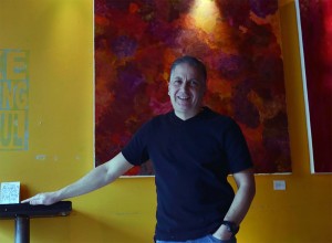 ​cutline- Angelo Marignani, 48, stands beside a painting in his downtown bar, the Milk Coffee Bar located on University Ave. W. on January 23, 2015. 