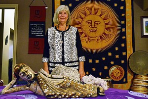 WINDSOR ON. OCTOBER 13, 2015--- Mary Kush, a guide in Mahatma Energy, poses by a fabric of a sun and a statue of a reclining Buddha, at the White Feather Holistic Arts center on 1350 Ottawa St. in Windsor. Mahatma Energy, according to Kush is the most powerful energy source on the planet. PHOTO BY/DAVID DYCK