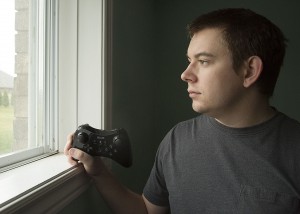 WINDSOR, Ont. (18/11/15) – Daniel Banner is pictured looking outside his bedroom and gaming room’s window while holding a Nintendo Wii U controller at his house in McGregor on Wednesday, Nov. 18, 2015. Photo by Justin Prince, The Converged Citizen