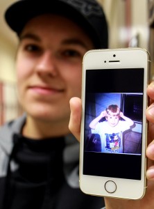 WINDSOR, Ont. (12/03/15) Brock Mulligan, 20, holds up his iPhone showing a photo of when he was younger inside the MediaPlex on Tuesday, Dec. 2, 2015. The photo depicts Mulligan when he was younger and when he identified himself as a female. Mulligan is in the middle of transitioning from female to male.  PHOTO BY/ Millar Hill