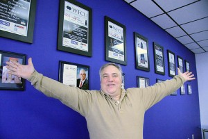 WESPY’s founder Domenic Papa stands with arms stretched across the WE-TV boardroom wall displaying posters of past WESPY award ceremonies in Windsor. Photo by Todd Shearon