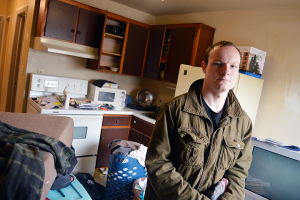 Jacob Caron stands in his apartment on Jan. 30. Until recently, Caron said he would not have dared to have his cupboards open for fear of the rodents that infested them. PHOTO BY/DAVID DYCK