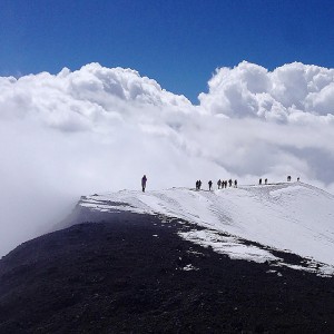 Travelers walk around the rim of one of Mount Etna's craters in Catania, Sicily.