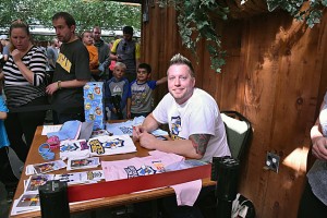 Fantastic Fathers founder Steven Brown sits at his table selling merchandise and autographed pictures to help support families in need this Christmas. Brown is looking to make the Fantastic Fathers group a registered charity to assist those in need. Photo by Alyssa Leonard