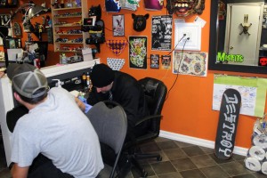 Artist Mike Knight tattooing a customer at Broken Skull Tattoo on Ottawa Street. Photo by Joe Gibel
