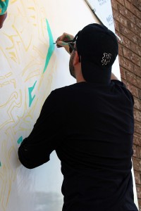 Artist Eric Faraci working on a mural on Drouillard Road during the festival. (Photo by Vanessa Cuevas)
