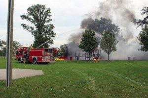 Firefighters extinguish the flames at Lacasse Park. (Photo By Kaitlynn Kenney)