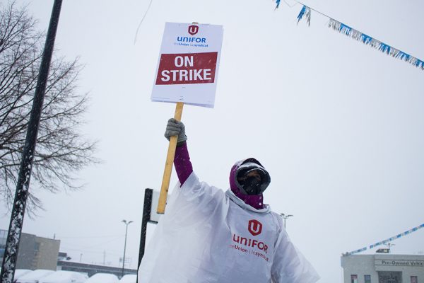 Motor City Chrysler employee and Unifor 195 member holds up her sign.
(Photo by Matt Flood)