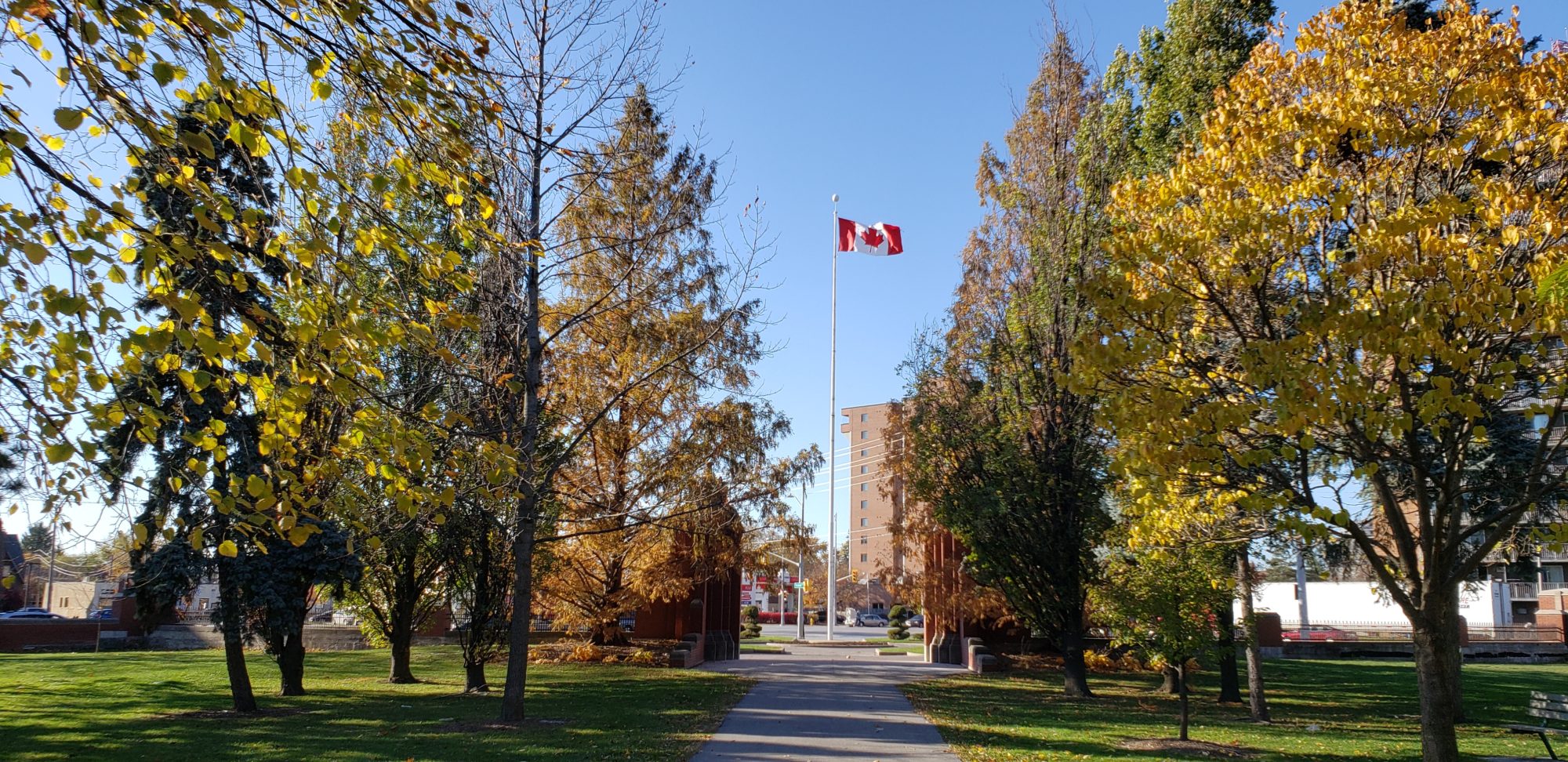 A large Canadian flag stands tall at the southwest entrance of Jackson Park.